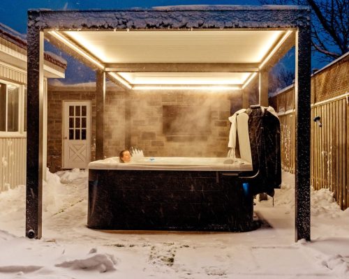 Louvered pergola over a hot tub in winter