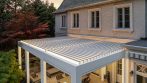 Elevated view of an attached aluminum pergola with adjustable white roof louvers.