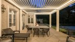 Garden pergola arranged as an outdoor living room with lounge seating and a dining table.