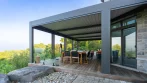 Pergola and deck connected to large sliding doors with an outdoor dining set