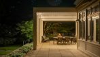 Screened garden pergola creating a comfortable outdoor room for dining and relaxing.