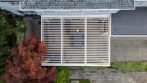 Top view of a white garden pergola with adjustable roof louvers fully open.