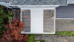 Top view of a garden pergola roof with adjustable louvers partially closed for shade.